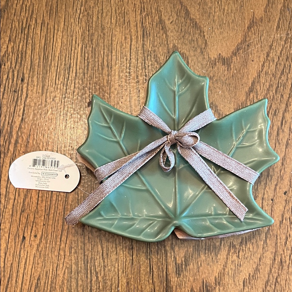 Two dark green leaf shaped ceramic appetizer plate